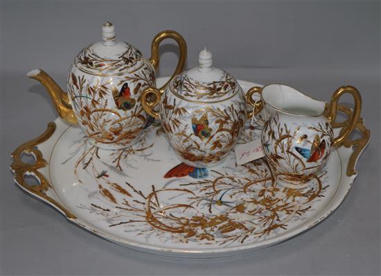 A porcelain four piece teaset, decorated with butterflies